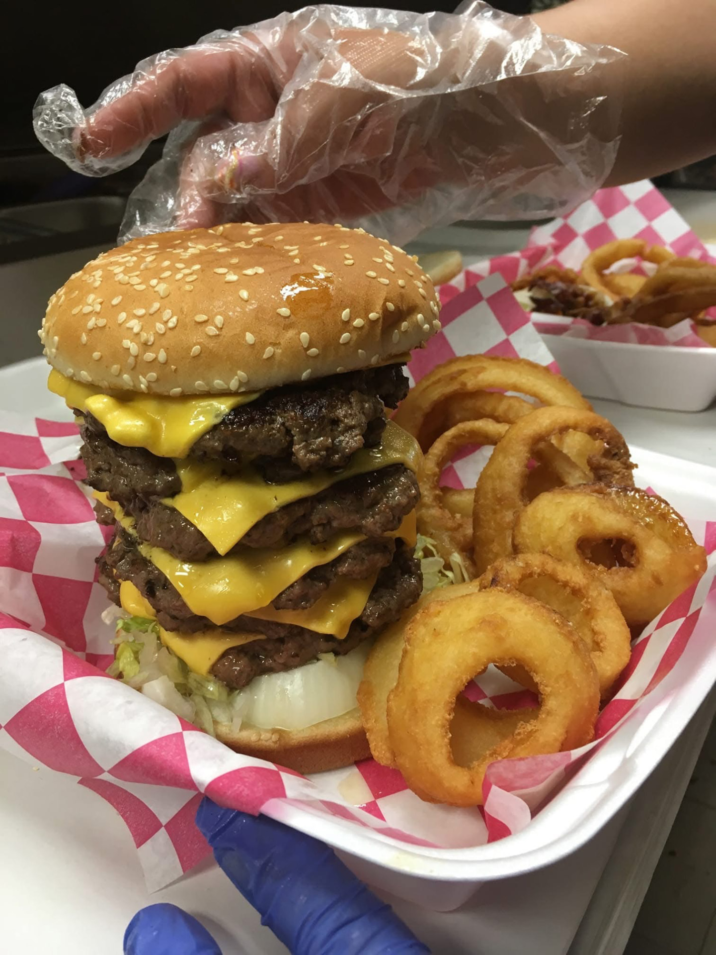 Stacked cheeseburger with melted cheese and onion rings